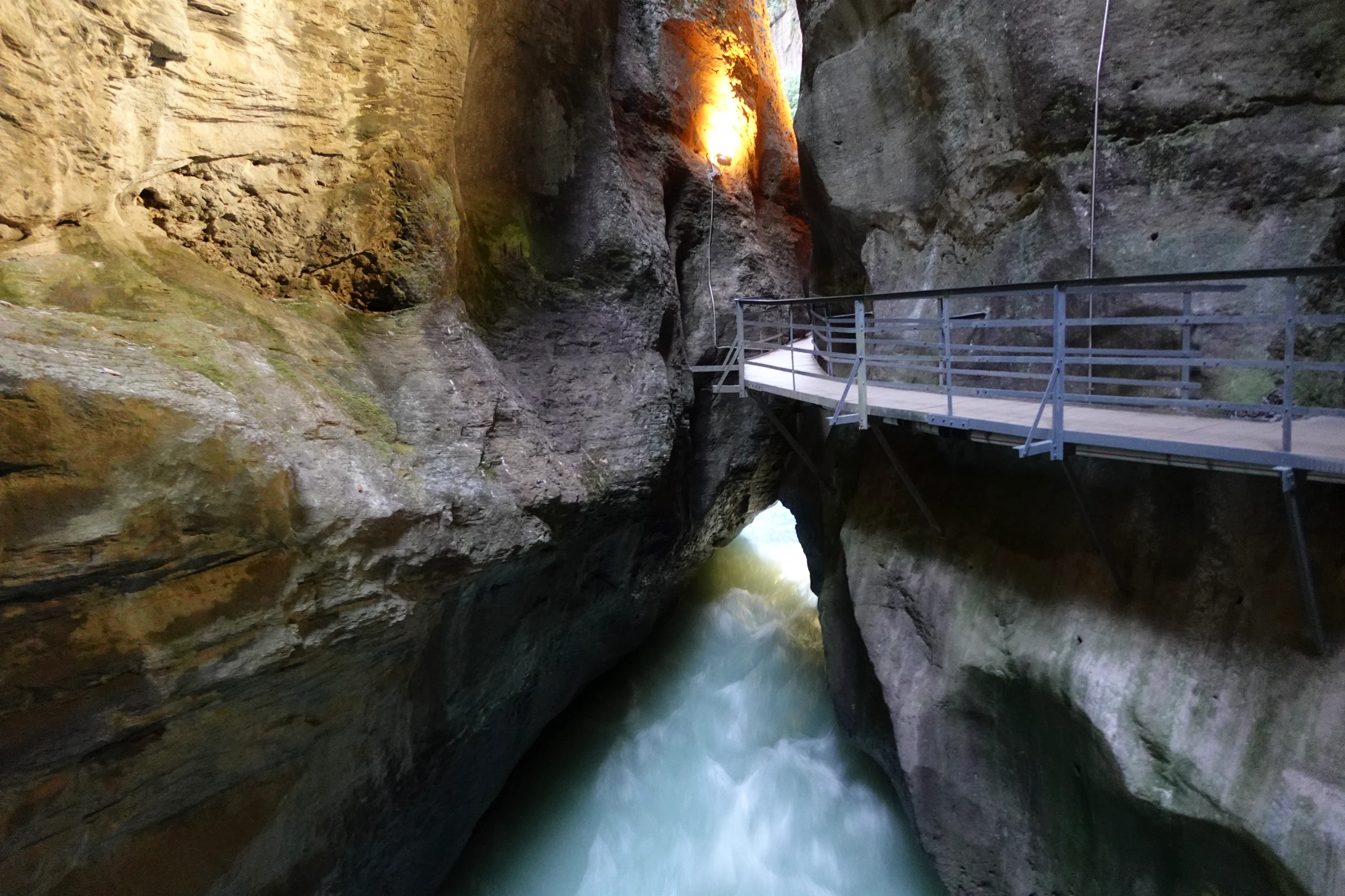 Beleuchtete Felswände und Steg über der Aare in der Aareschlucht am Abend