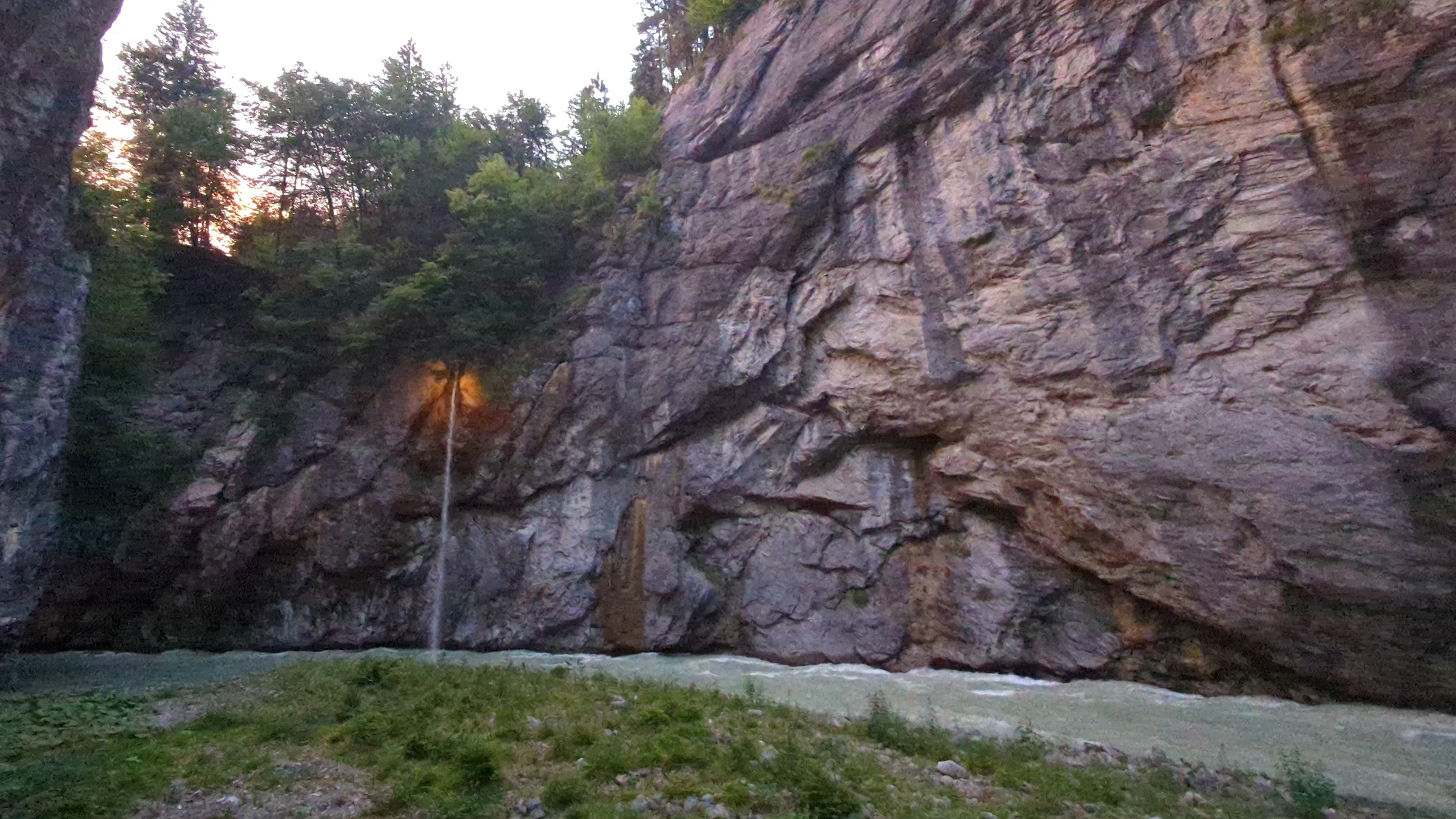 Schräybach-Wasserfall in der Dämmerung, von einer Lampe beleuchtet, im breiten Teil der Aareschlucht