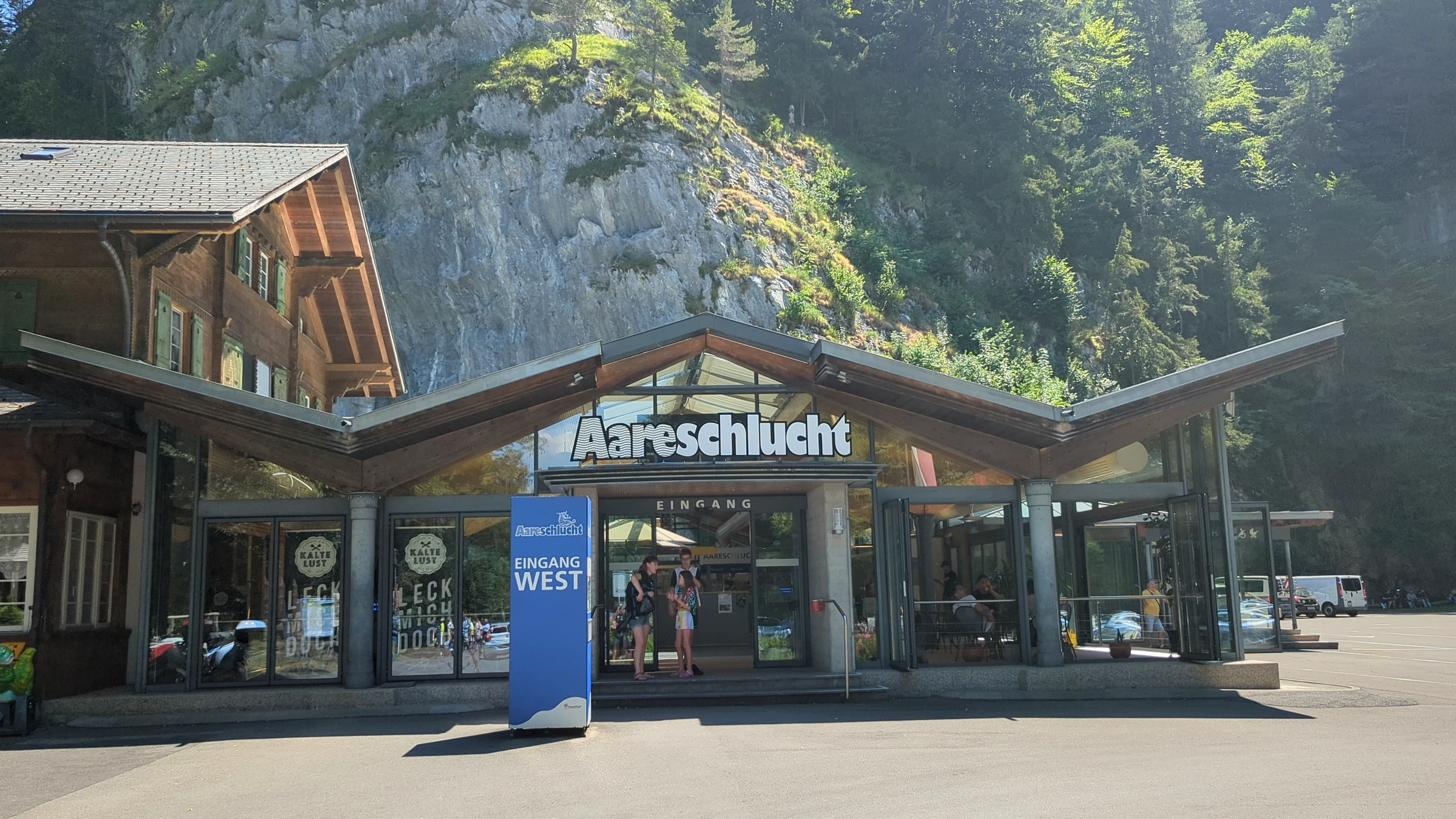Holzgebäude mit Aareschlucht-Schriftzug und Fahne Eingang West in Meiringen
