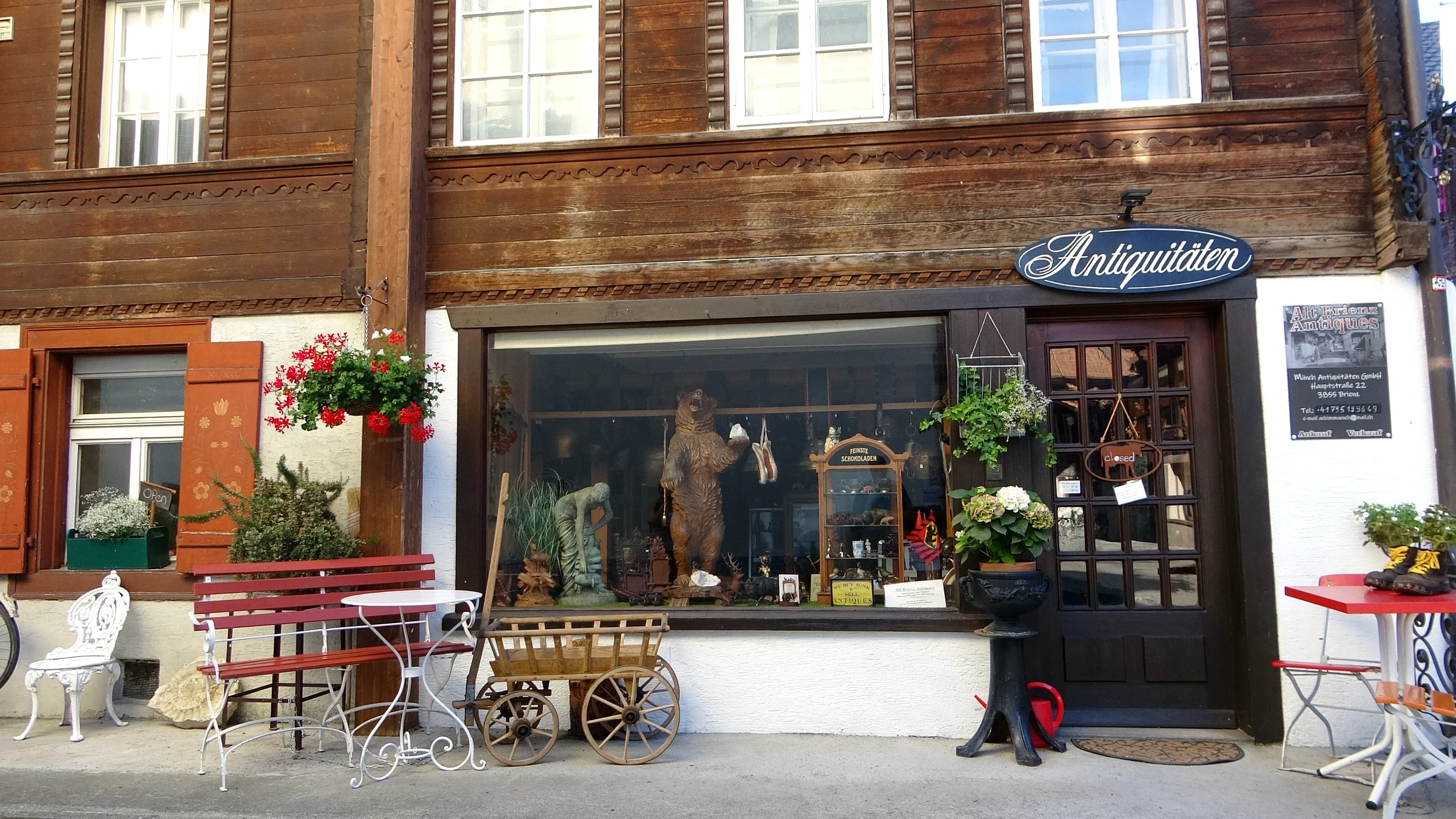 Antiquitätengeschäft in einem alten Holzhaus in Brienz mit Schnitzereien und Leiterwagen vor dem Schaufenster