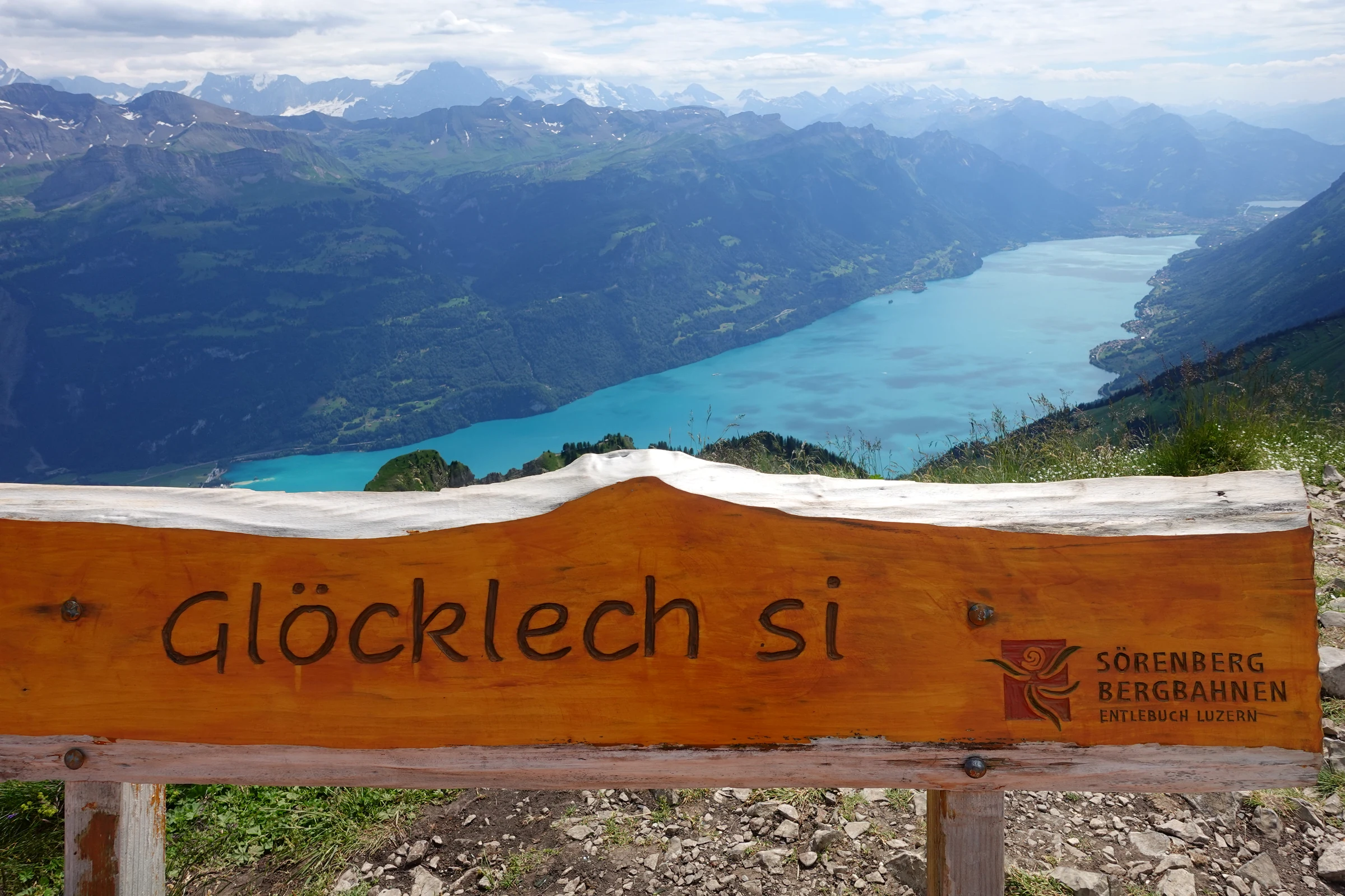 Holzbank mit der Aufschrift Glöcklech si über dem Brienzersee am Grat des Brienzer Rothorns
