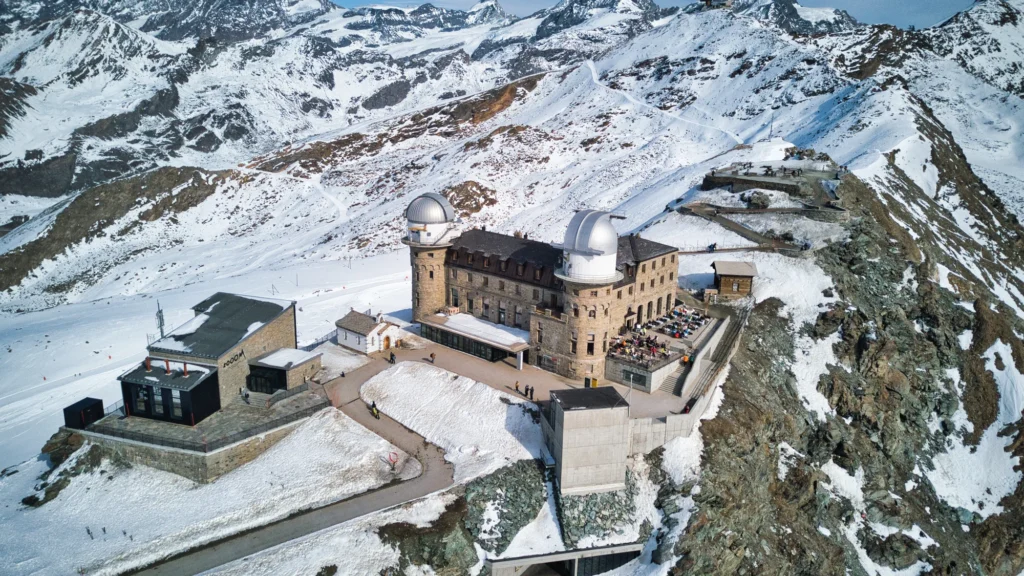 The Kulmhotel Gornergrat seen from above, with its two observatory domes and viewing terraces on the snowy ridge