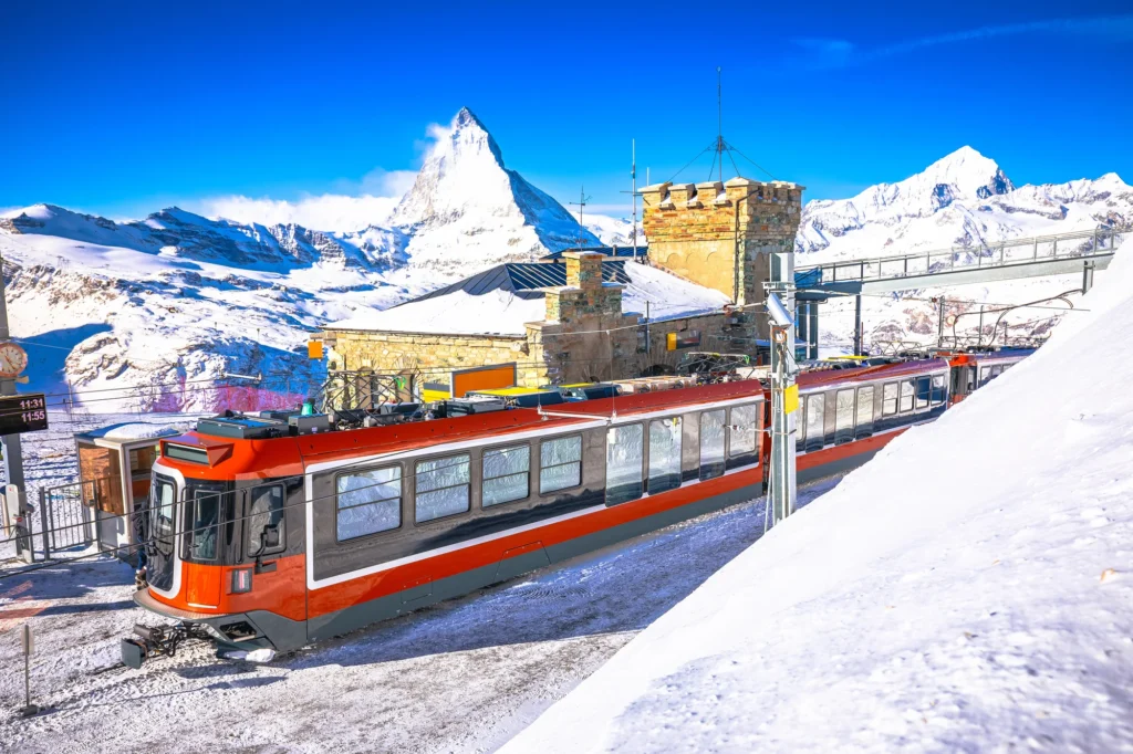 Gornergrat summit station with a red train in the snow and the Matterhorn