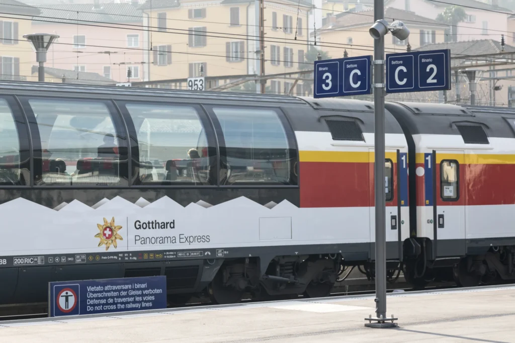First-class panoramic coach of the Gotthard Panorama Express with logo at Bellinzona station