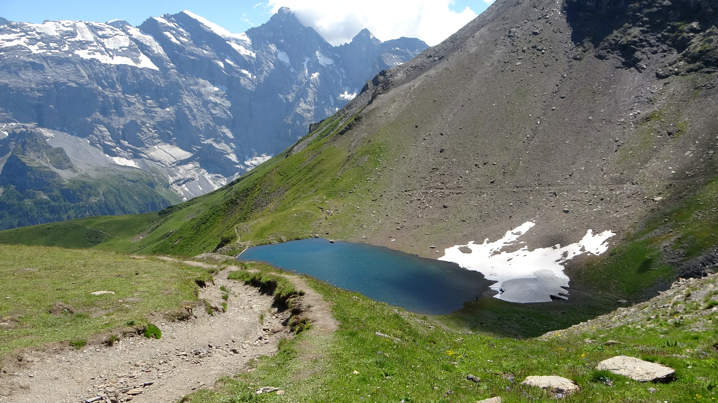 Grauseeli vom Wanderweg aus gesehen, mit einem Schneefeld im Juli