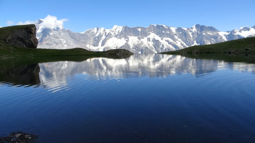 Die Berner Alpen spiegeln sich im stillen Wasser des Grauseeli unterhalb der Birg