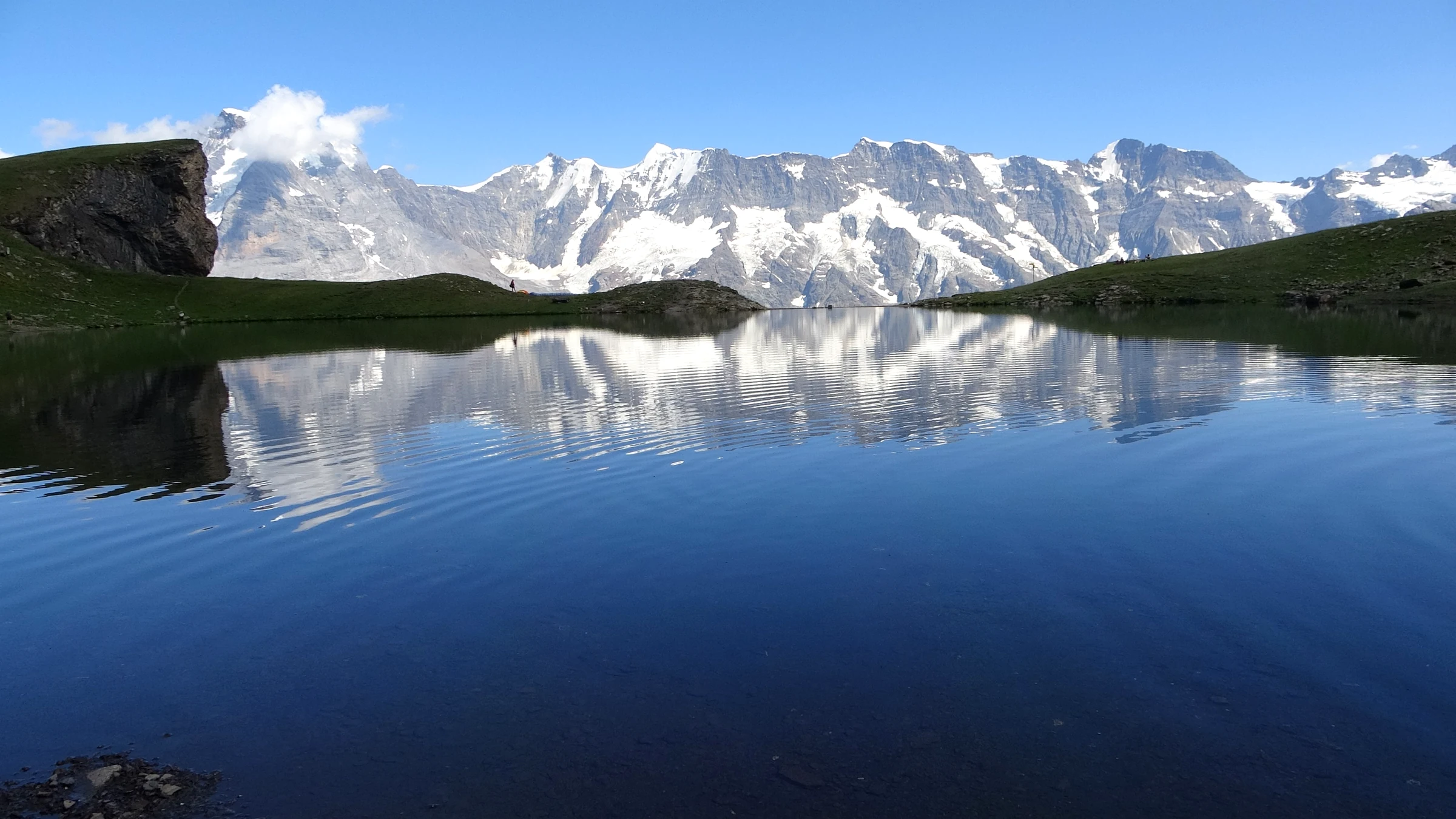 Die Berner Alpen spiegeln sich im stillen Wasser des Grauseeli unterhalb der Birg