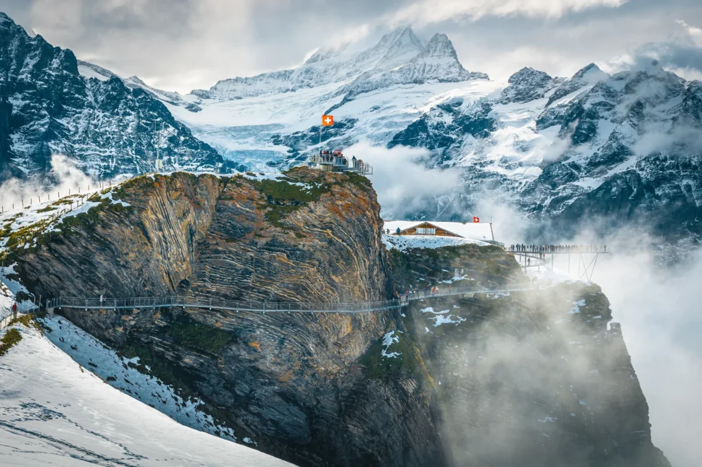 Metallsteg des First Cliff Walk an einer Felswand mit verschneiten Gipfeln