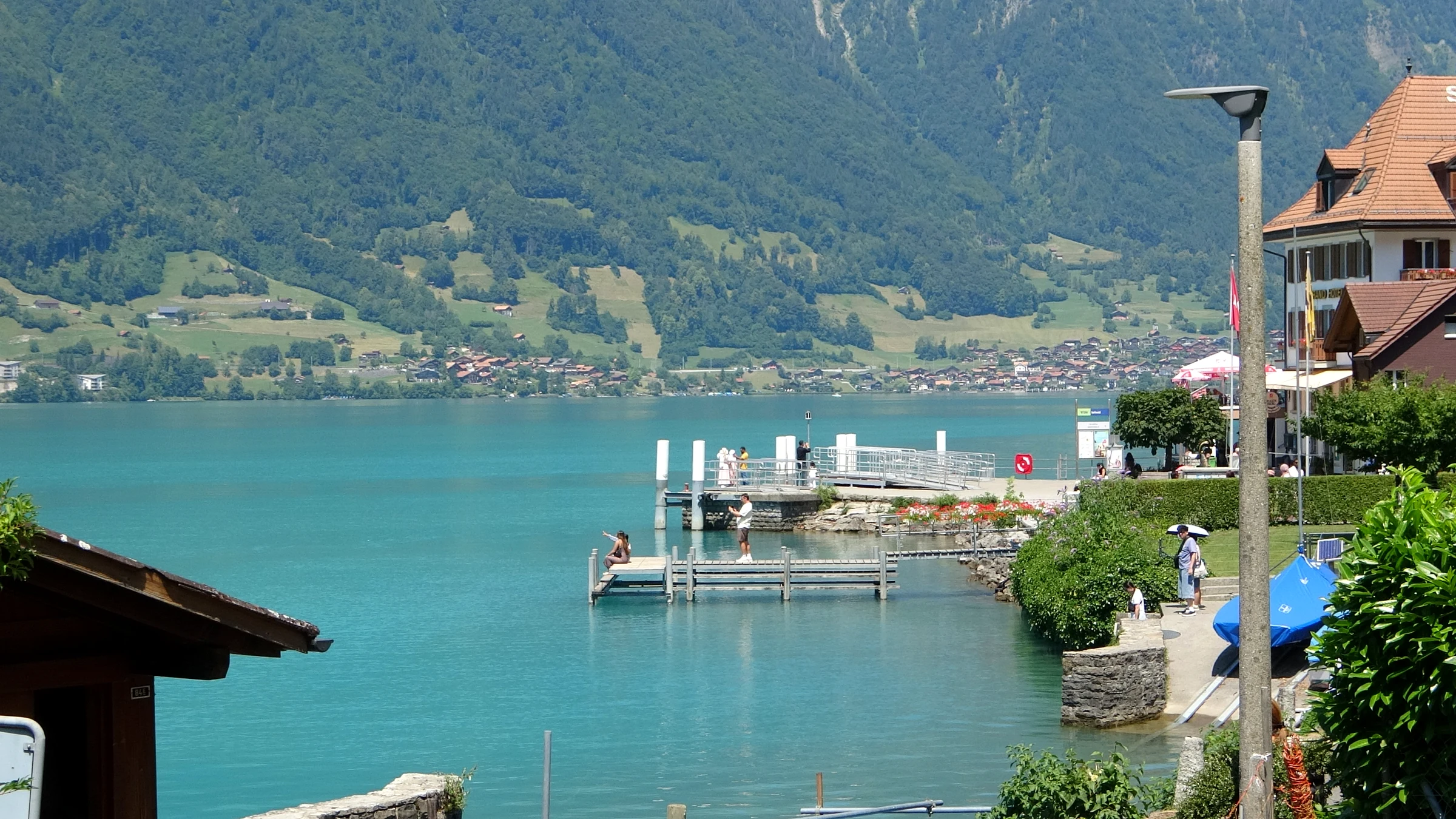 Boat landing of Iseltwald with the Strandhotel and the jetty in the bay of Lake Brienz