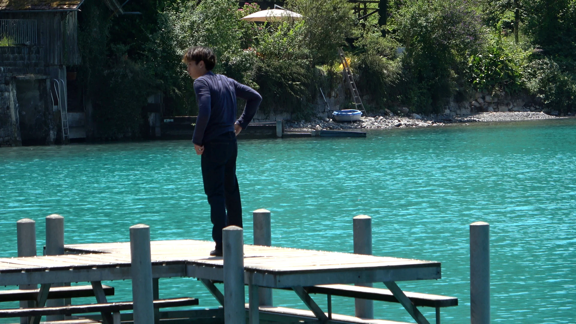 Influencer standing at the end of the Iseltwald pier above turquoise water