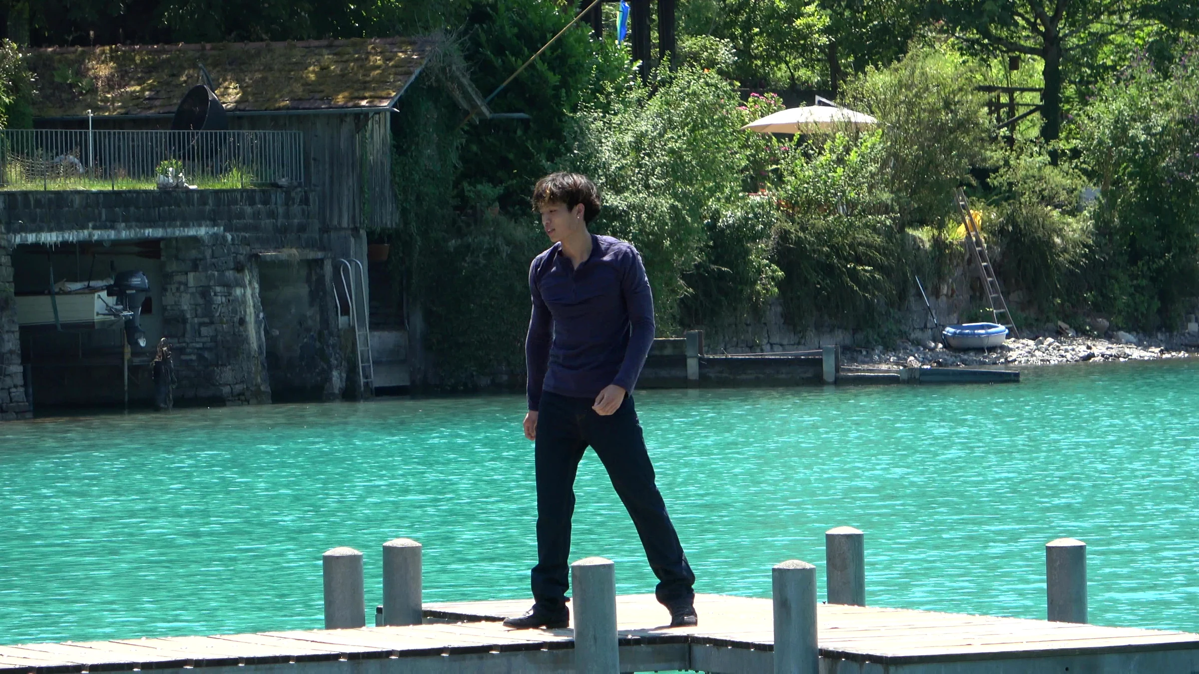 Influencer walking towards the camera on the Iseltwald pier with the lake behind him