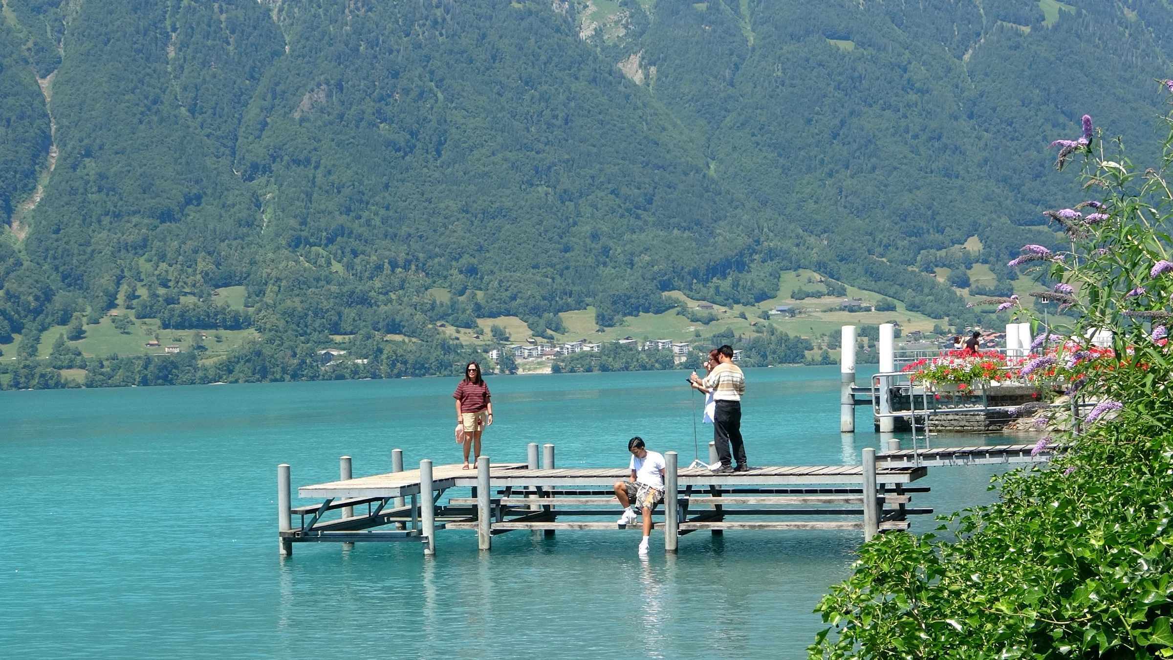 Visitors posing at the end of the Crash Landing on You pier in Iseltwald while others wait their turn