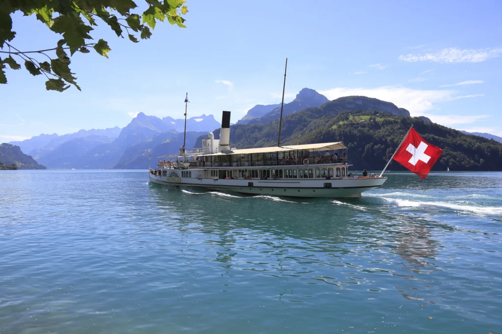 Paddle steamer with Swiss flag sailing on Lake Lucerne