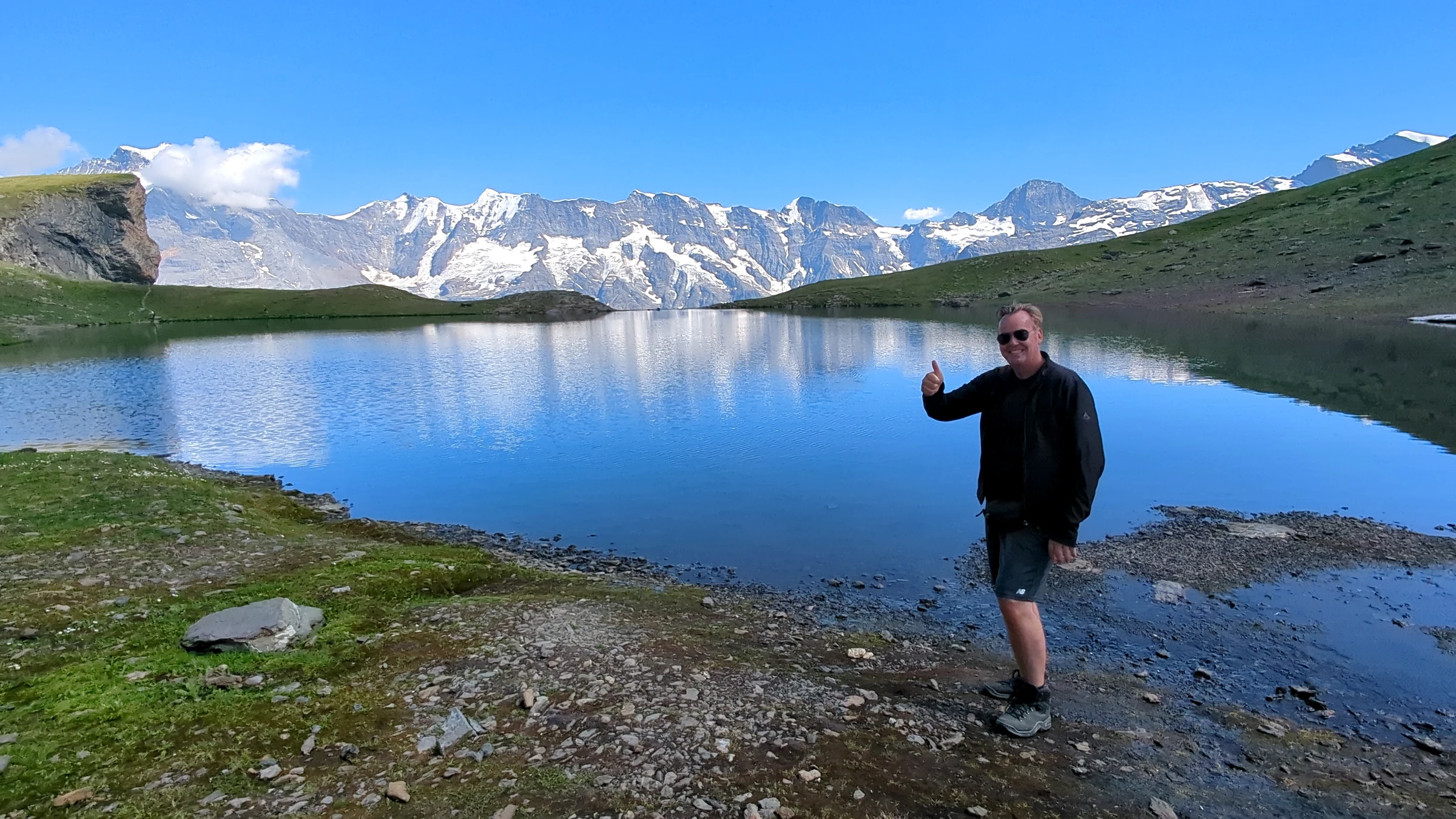 Author Alexander Haselhoff at the Grauseeli below Birg, with snowy peaks reflected in the mountain lake