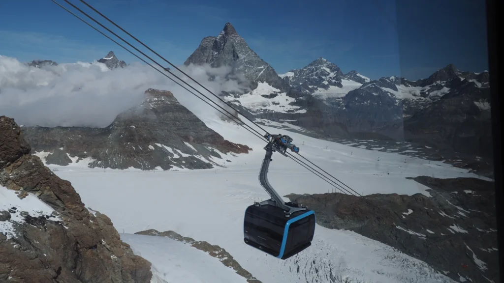 Gondola cabin of the Matterhorn Glacier Ride over the glacier with the Matterhorn and a sea of clouds behind