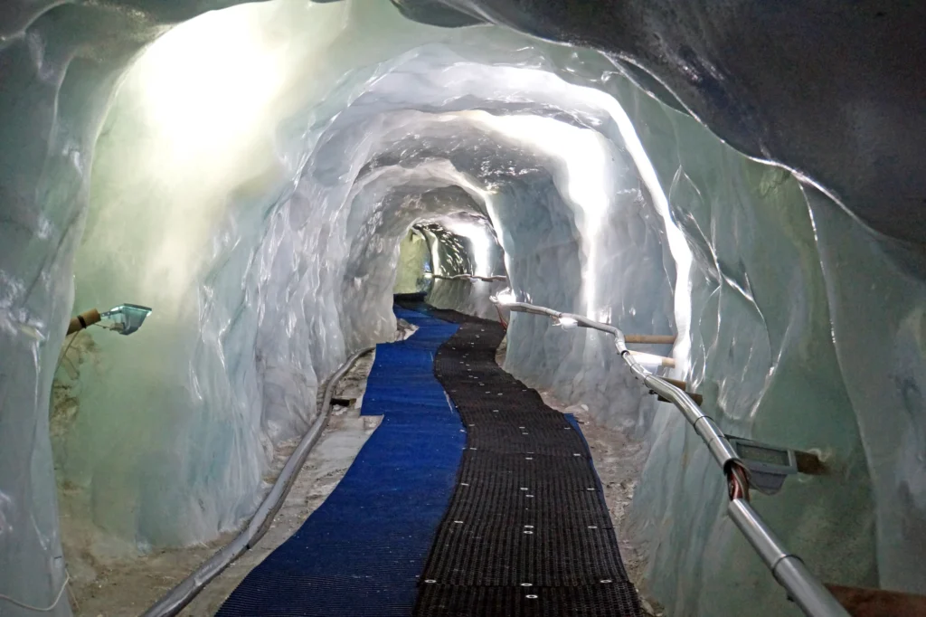 Glacier Palace tunnel inside the ice with a blue walkway and lights along the ice walls