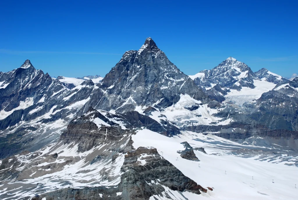 The Matterhorn rising above glaciers and snowy ridges, seen from the Klein Matterhorn under a blue sky