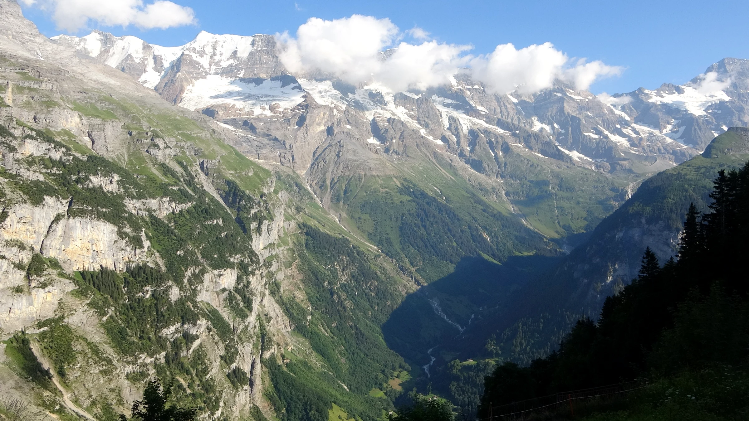 Blick vom Dorfrand von Mürren hinunter ins Lauterbrunnental mit Gletschern am Talschluss