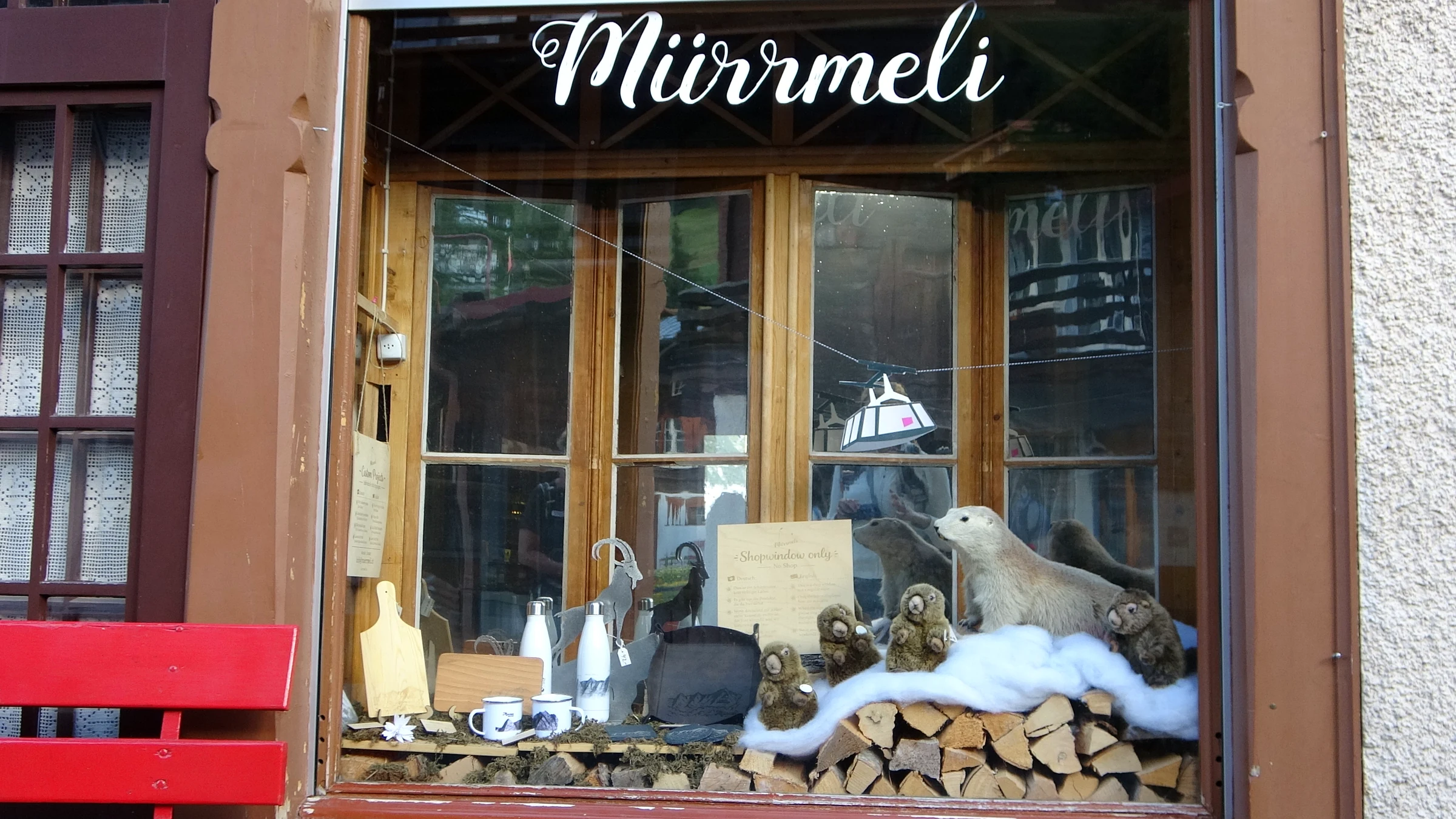Schaufenster Mürrmeli mit Plüsch-Murmeltieren auf Brennholz und Kunstschnee