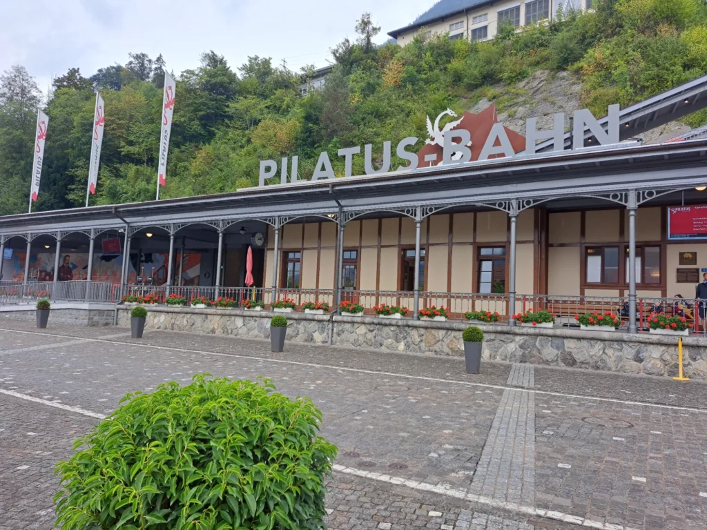 Talstation der Pilatusbahn in Alpnachstad mit grossem Schriftzug PILATUS BAHN und Blumenkästen