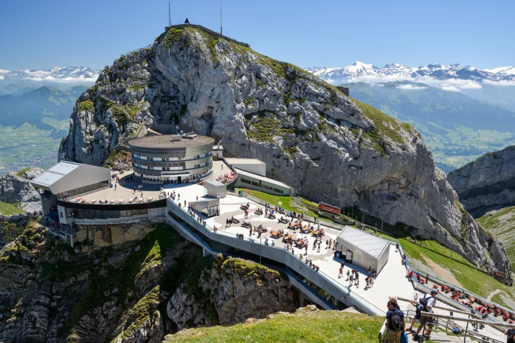 Hotel und Aussichtsterrassen auf dem felsigen Gipfel Pilatus Kulm an einem sonnigen Tag