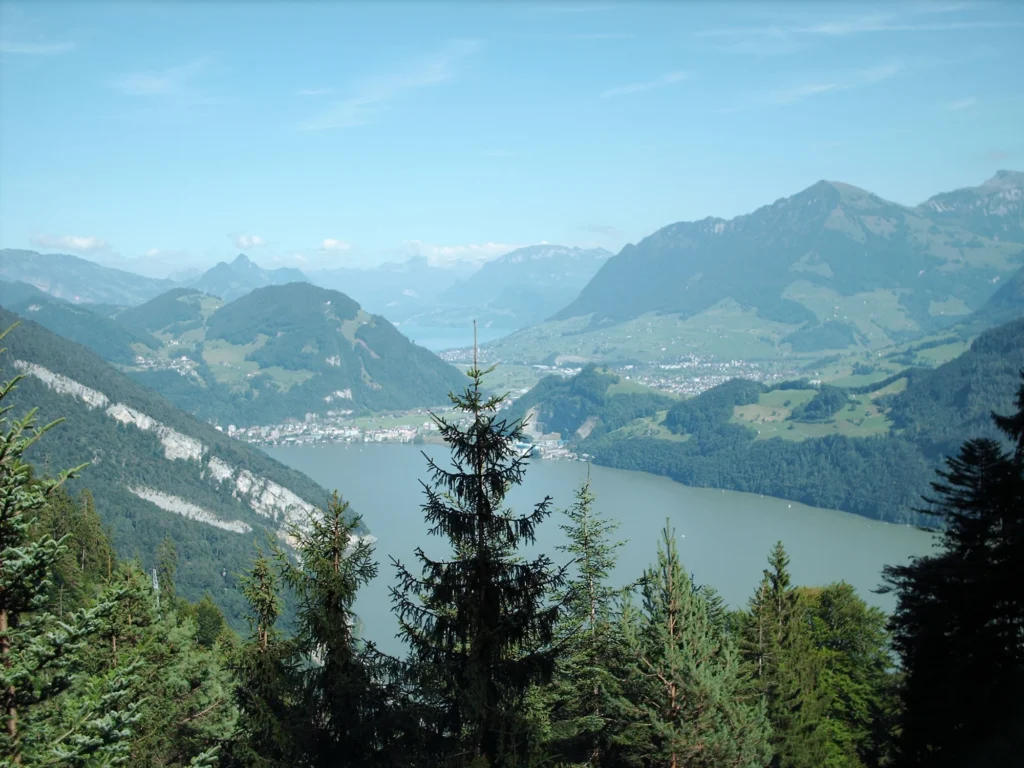 Blick aus der Pilatusbahn über Wald auf den Alpnachersee und die Berge der Zentralschweiz