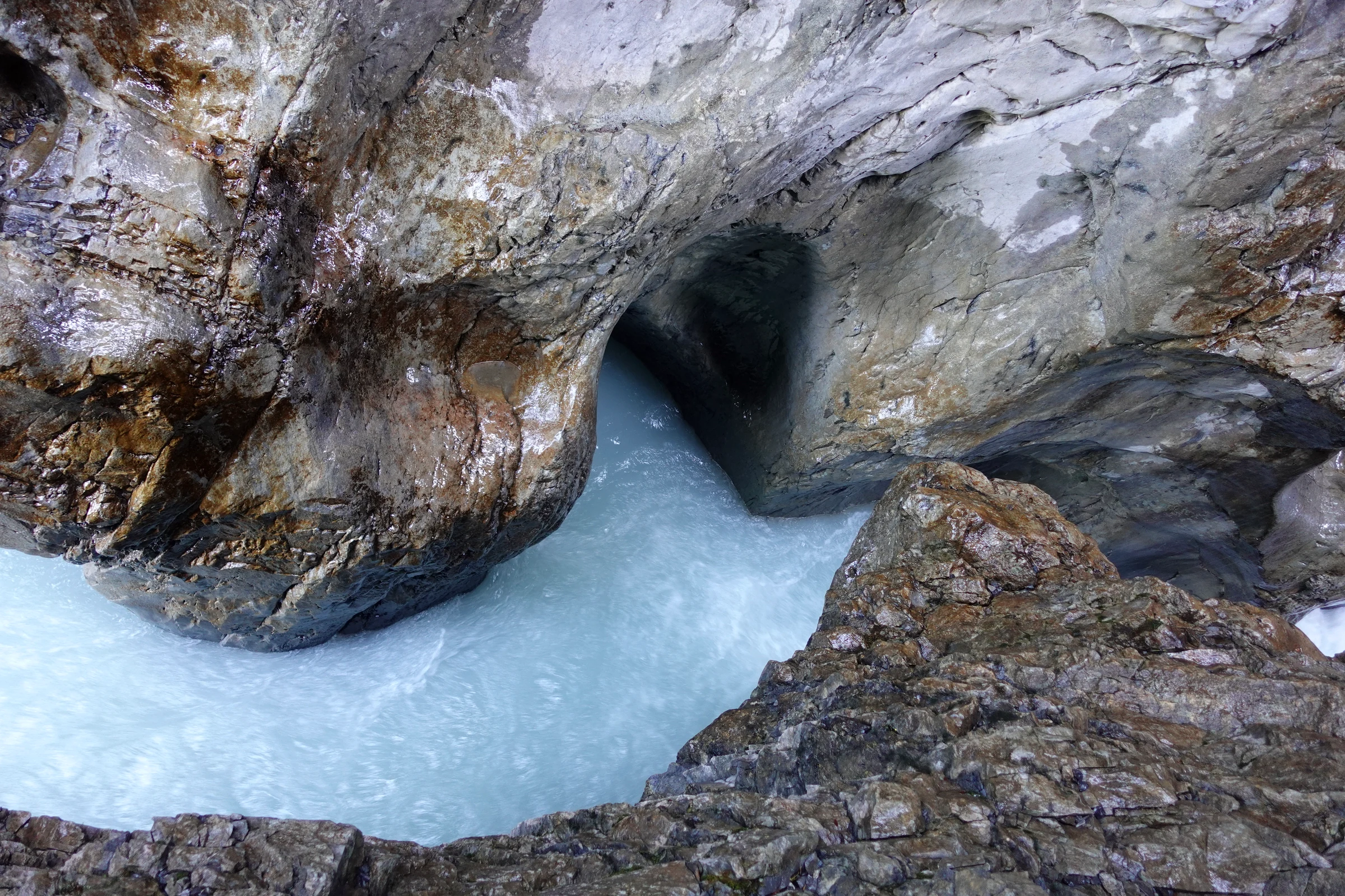 Türkisfarbenes Gletscherwasser strudelt durch einen glattgeschliffenen Gletschertopf in der Gletscherschlucht Rosenlaui