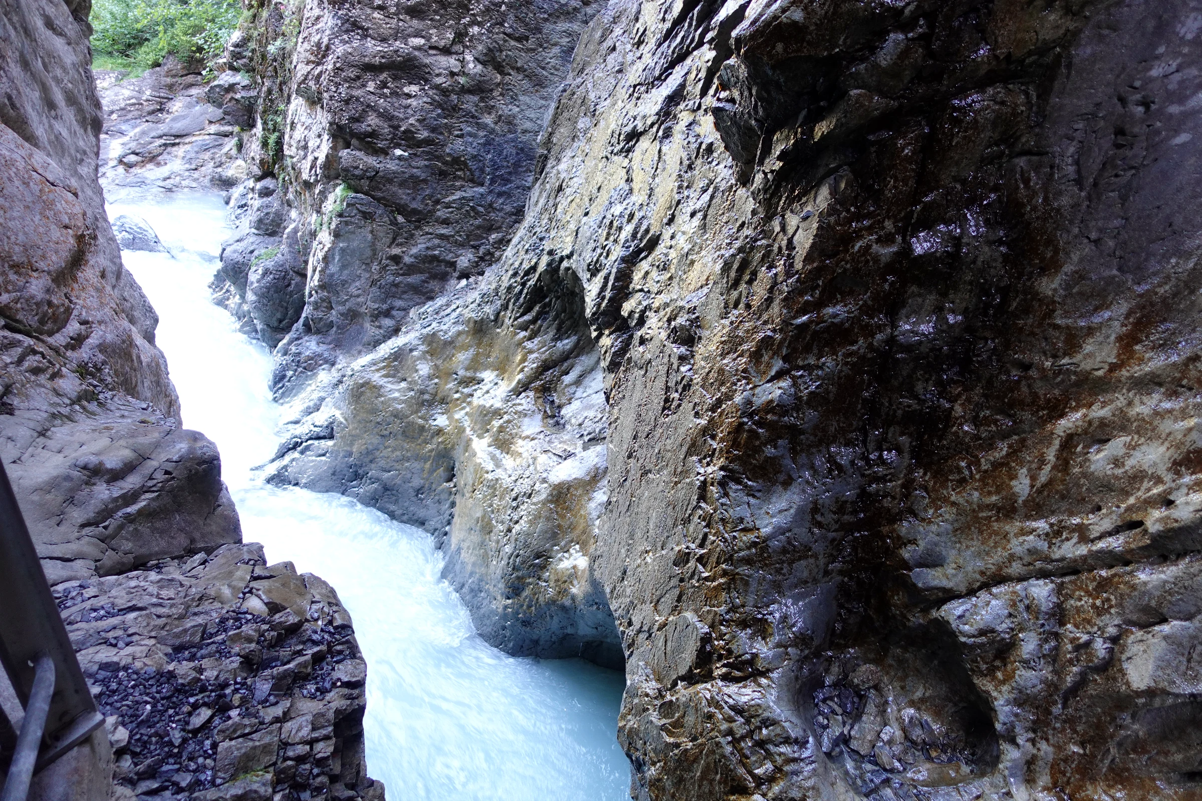 Enge Stelle der Gletscherschlucht Rosenlaui mit senkrechten grauen Kalkwänden und weißem Wasser