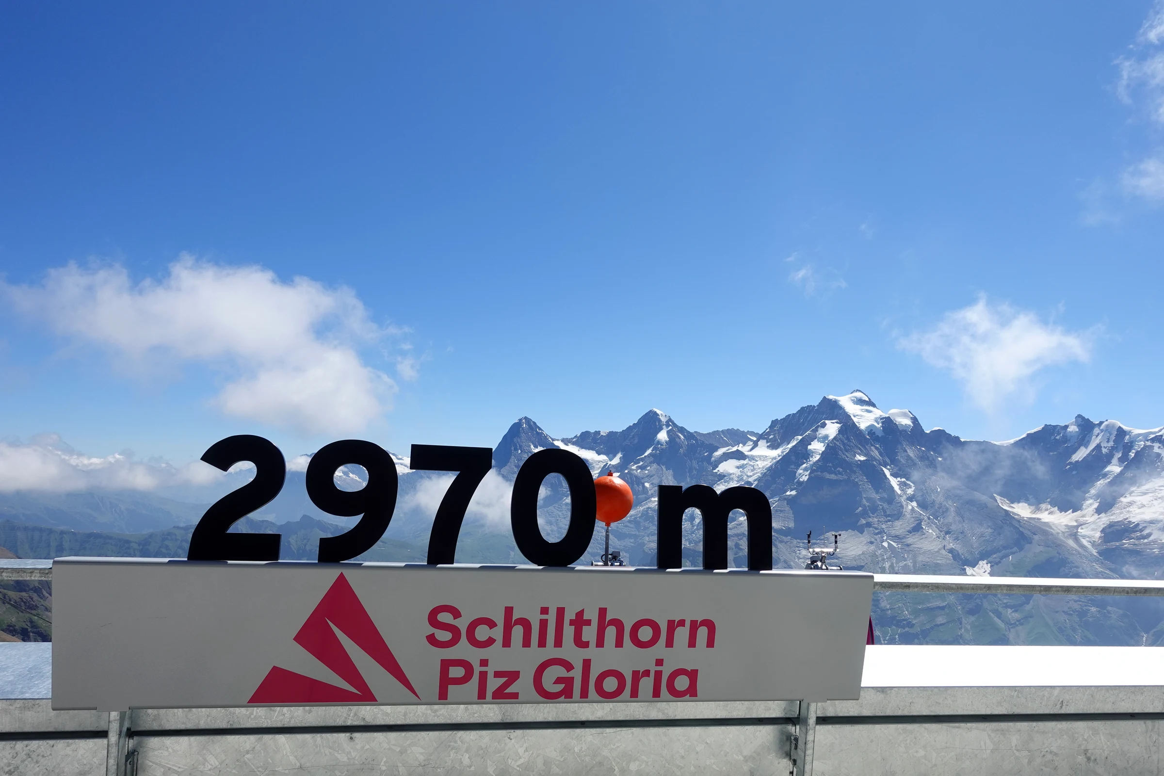 Schild 2970 m auf der Gipfelterrasse des Schilthorns vor den Berner Alpen