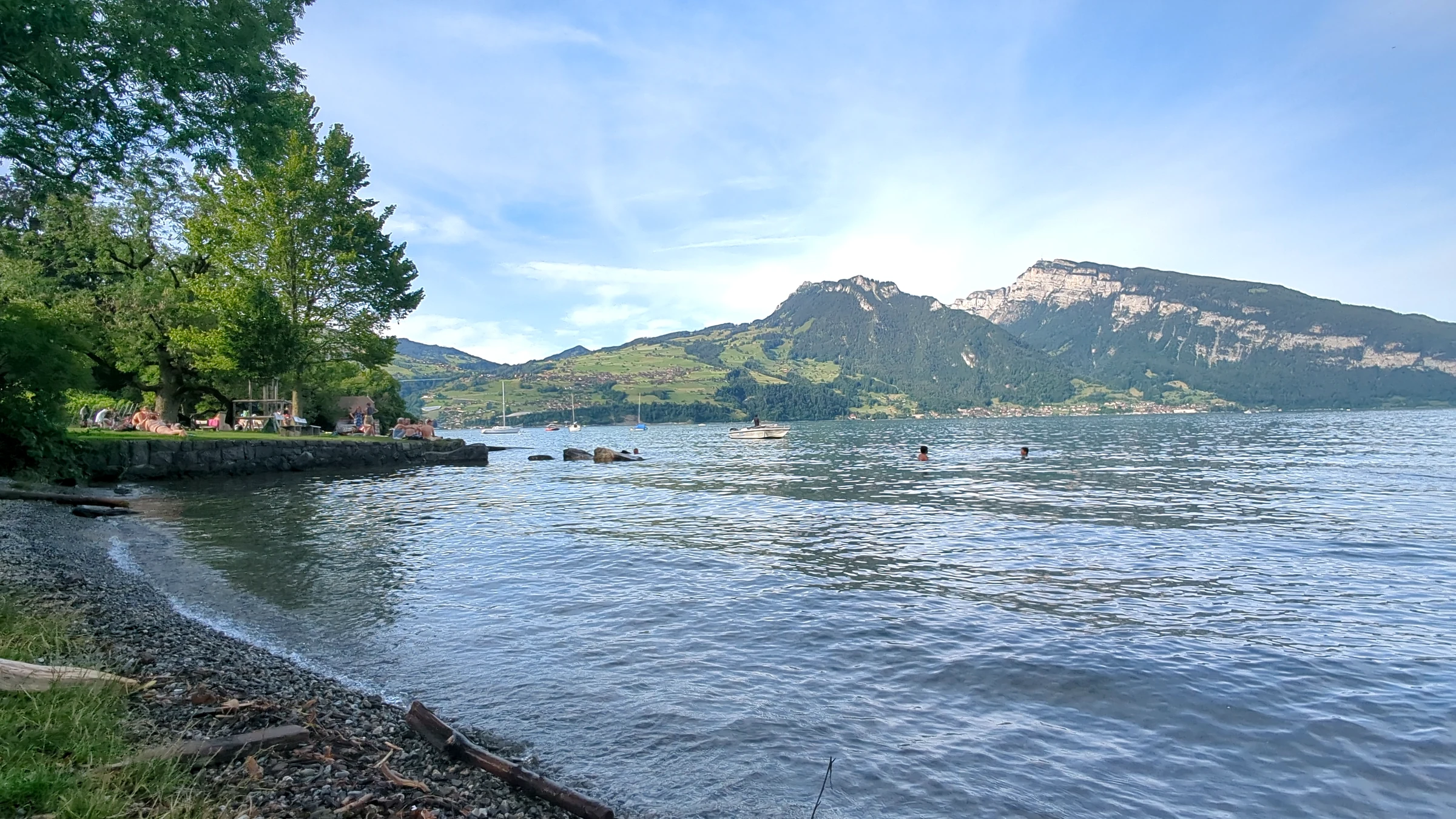 Abendlicht am Thunersee bei Spiez mit Kiesufer, Bäumen und den Bergen am Nordufer