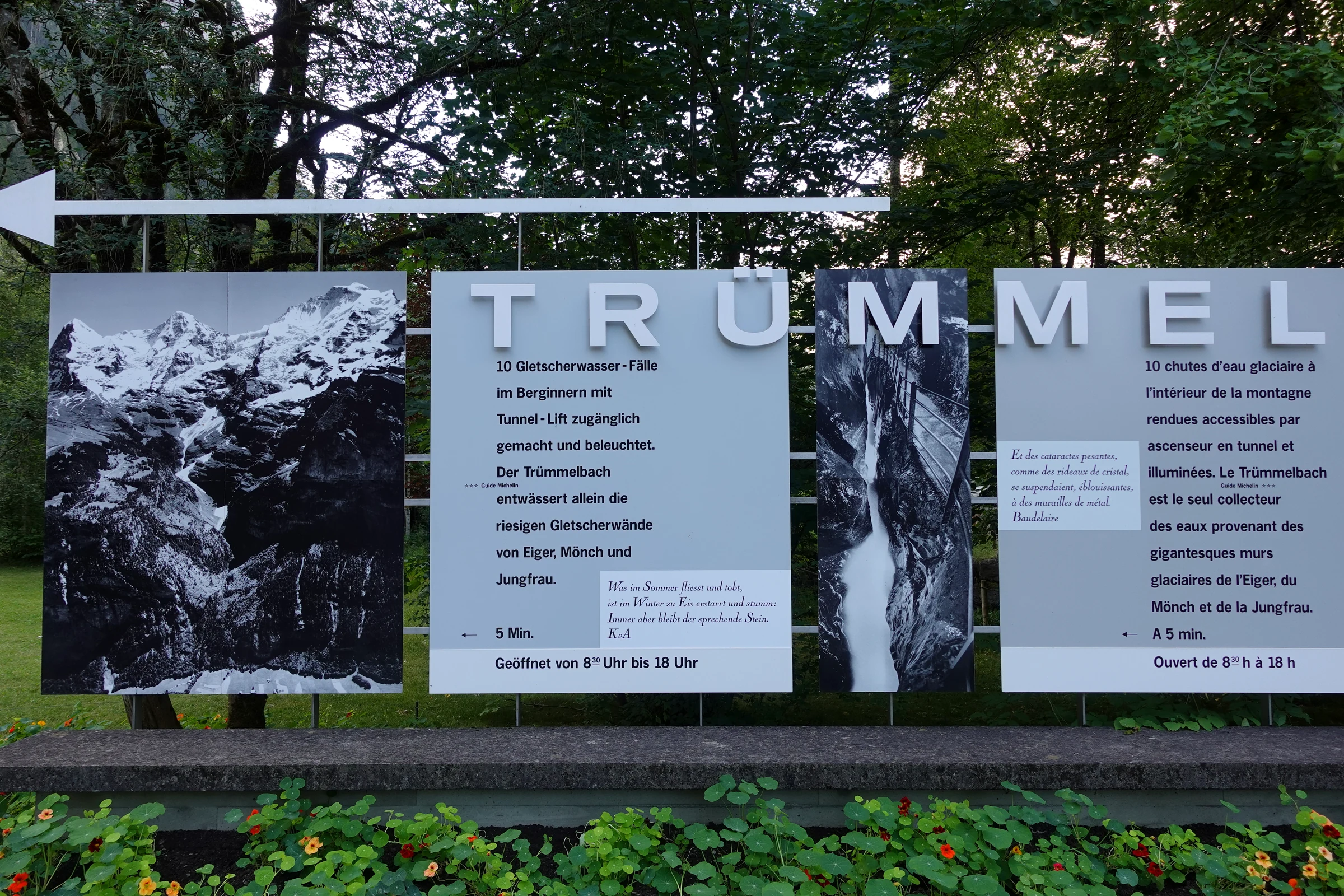 Grosse Schautafel der Trümmelbachfälle am Eingang mit Schwarzweissfotos und Öffnungszeiten