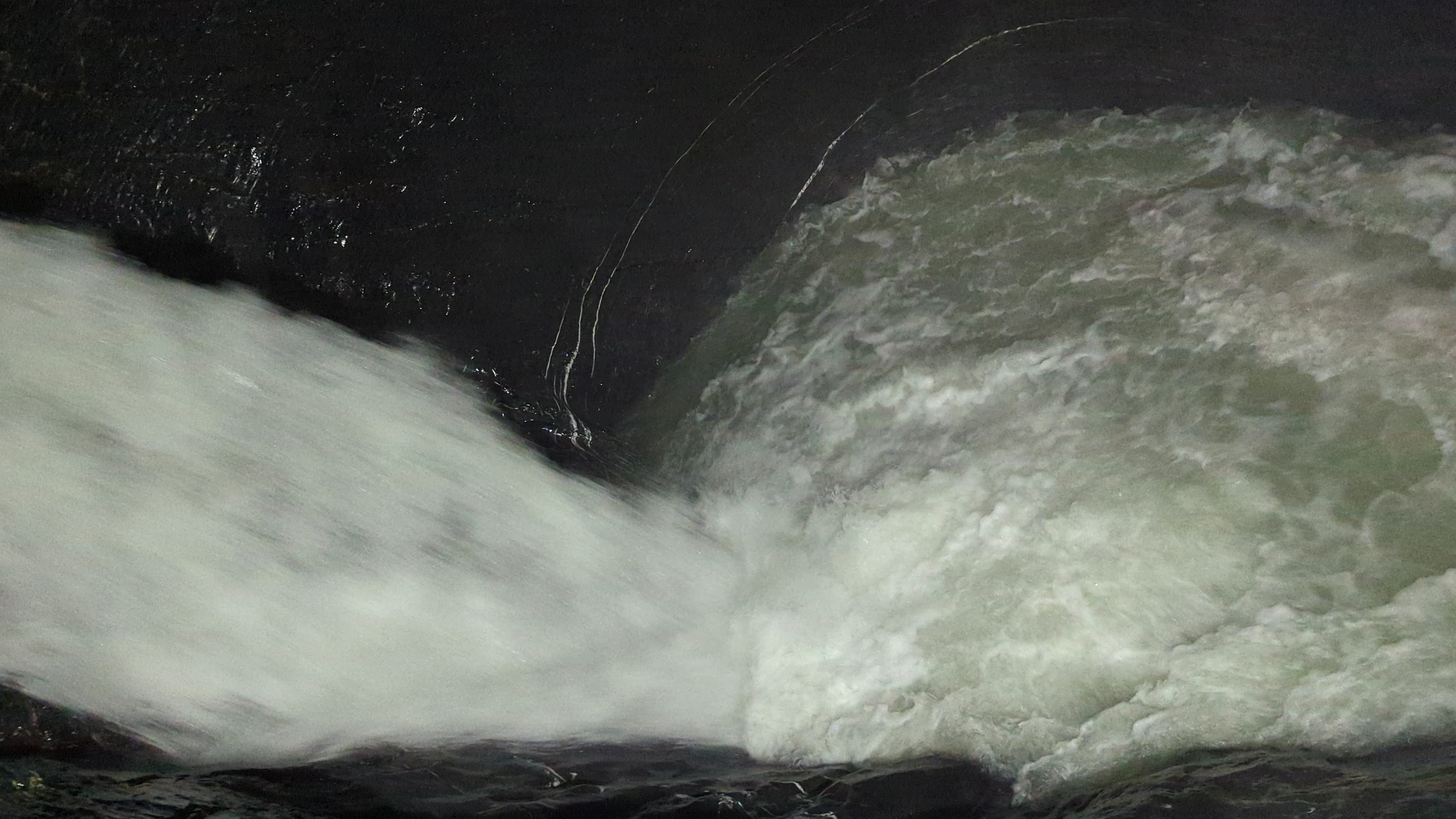 Milchiges Gletscherwasser stürzt in ein Becken in der Trümmelbachschlucht