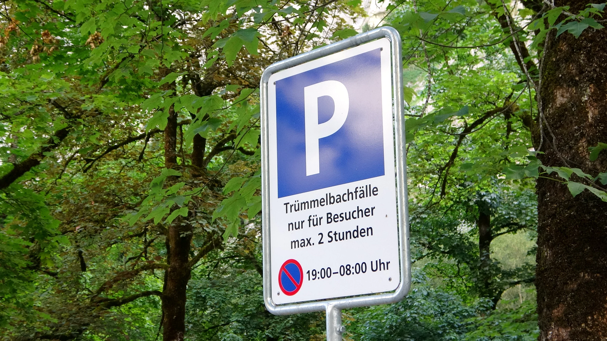 Parkplatzschild der Trümmelbachfälle: nur für Besucher, maximal 2 Stunden, Parkverbot von 19 bis 8 Uhr