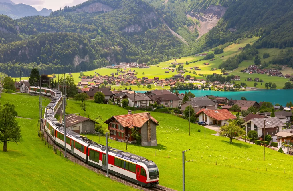 Red Zentralbahn panorama train passing the village of Lungern